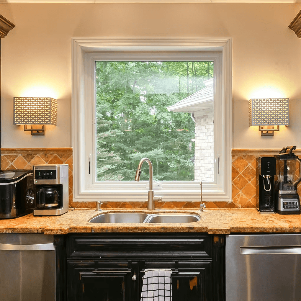 Awning window above a double kitchen sink with sconces